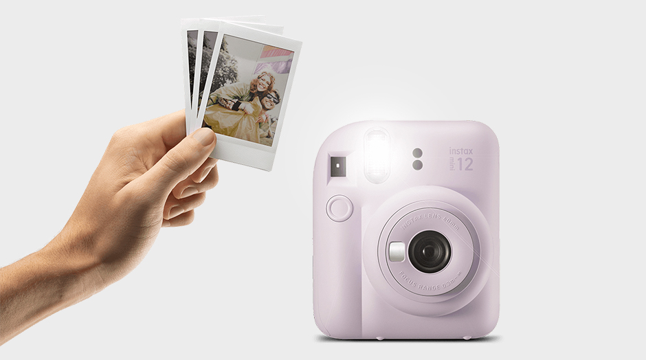 mquina fotogrfica instax mini 12 lils e mo com fotos na mo ao lado