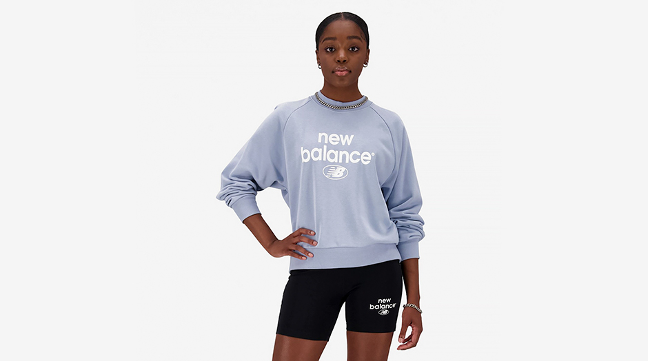 mulher negra com cales pretos e camisola azul da new balance