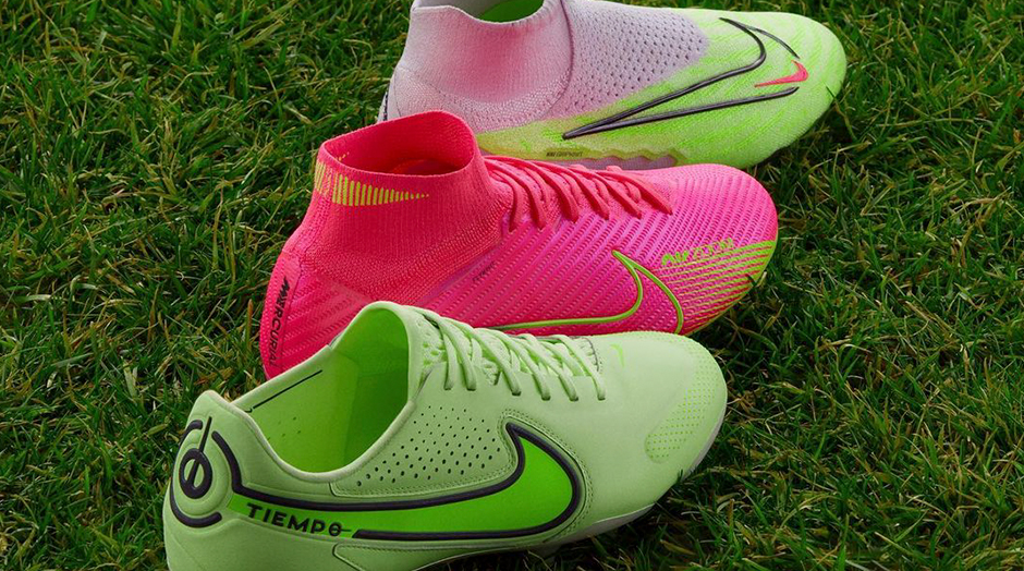 trs chuteiras nike. verdes e rosa em relvado